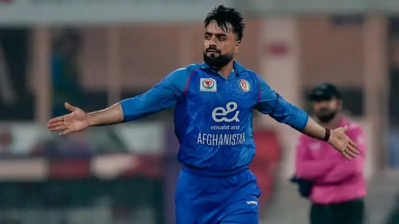 Rashid Khan celebrating a wicket, Ibrahim Zadran hitting a boundary, Sharjah crowd buzzing under floodlights.
